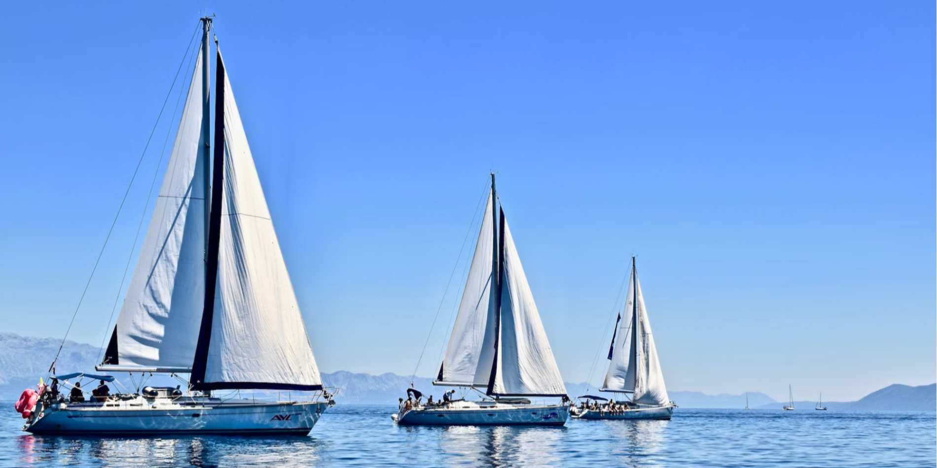3 sailboats on the water during daytime