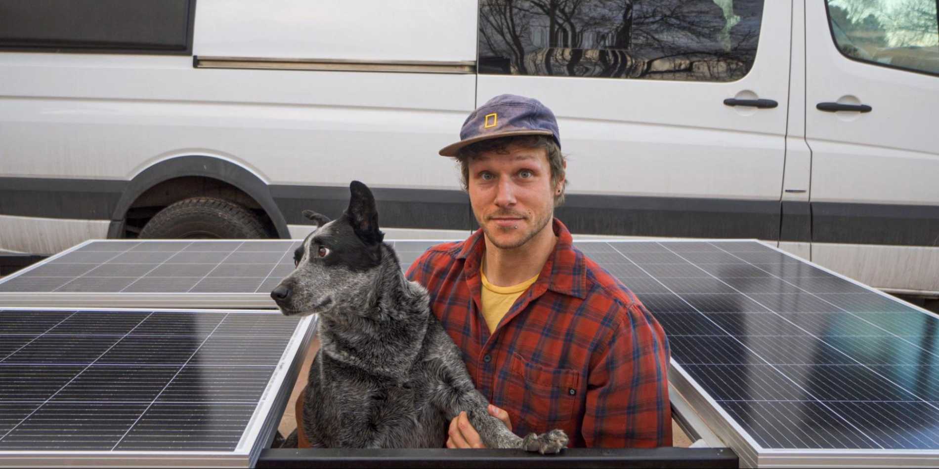 A man holding a dog in front of BougeRV’s 100W and 200W solar panels